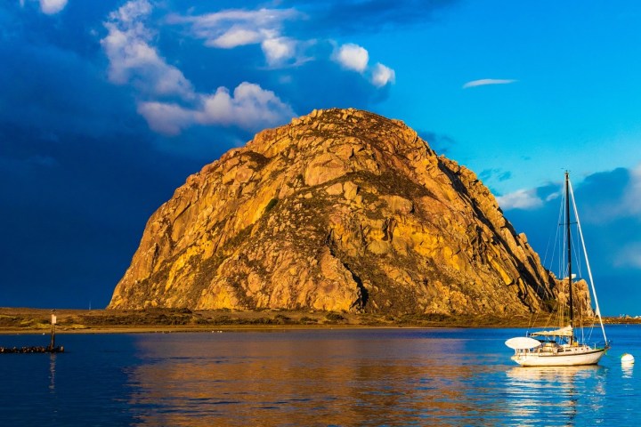 a small boat in a body of water with a mountain in the background