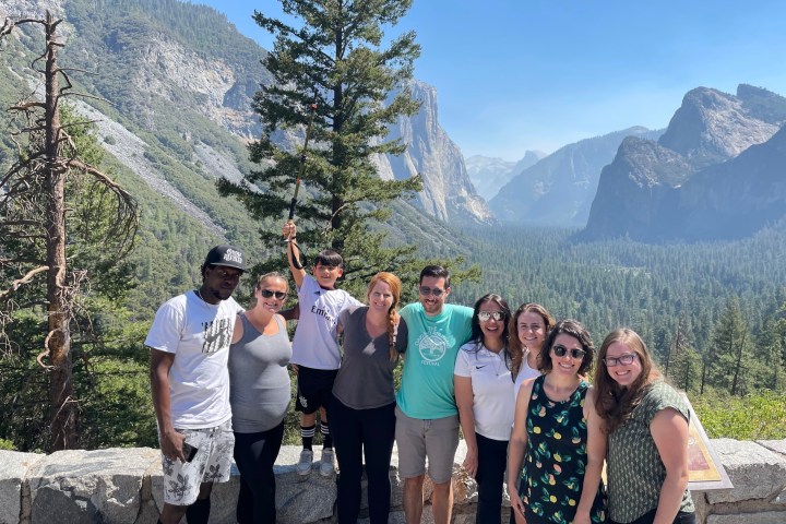 a group of people standing in front of a mountain